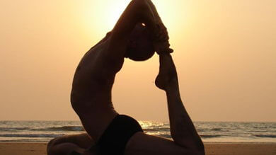 Gosta on the beach in yoga asana ekapadarajakapotasana